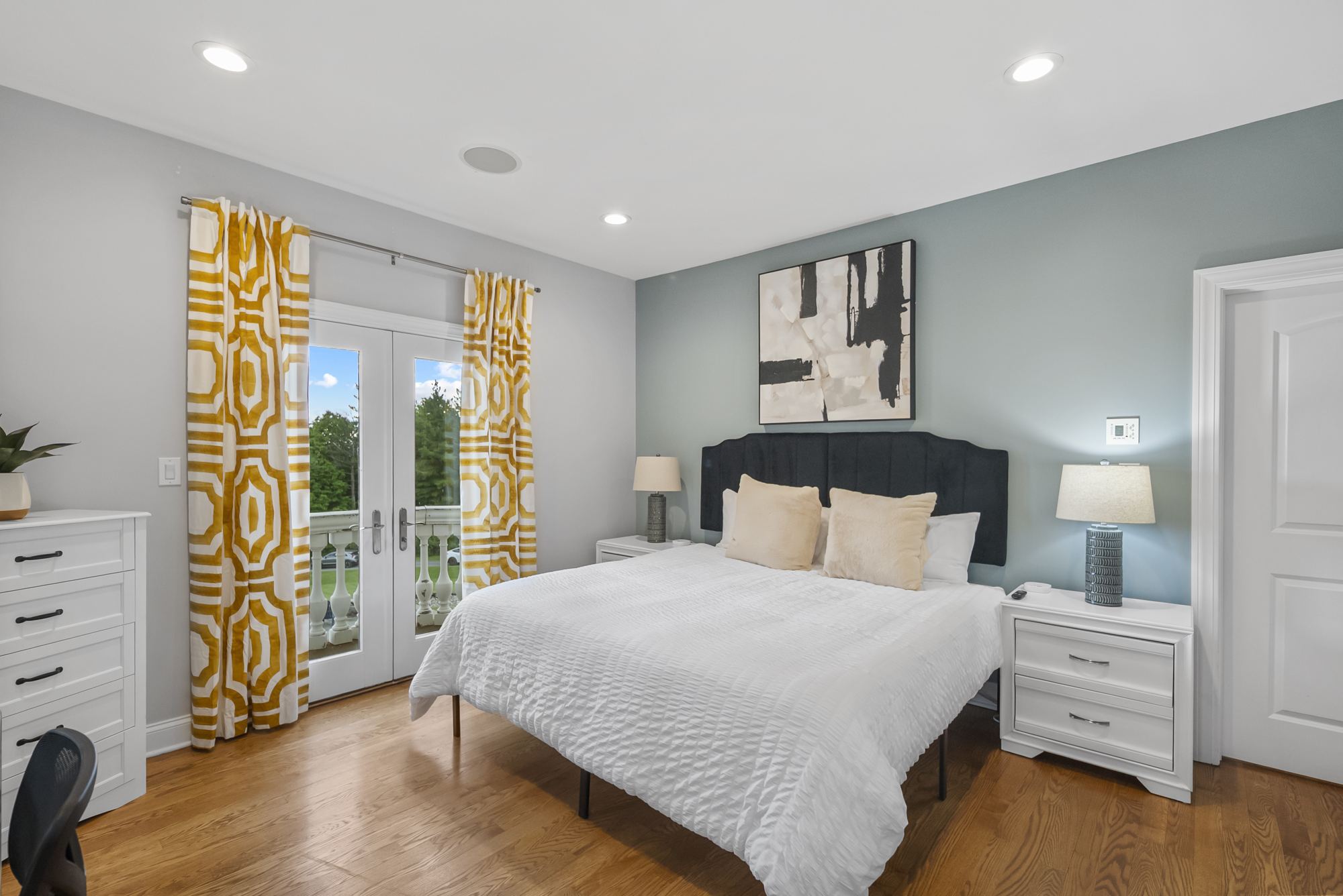 Bedroom with gold drapes and balcony doors
