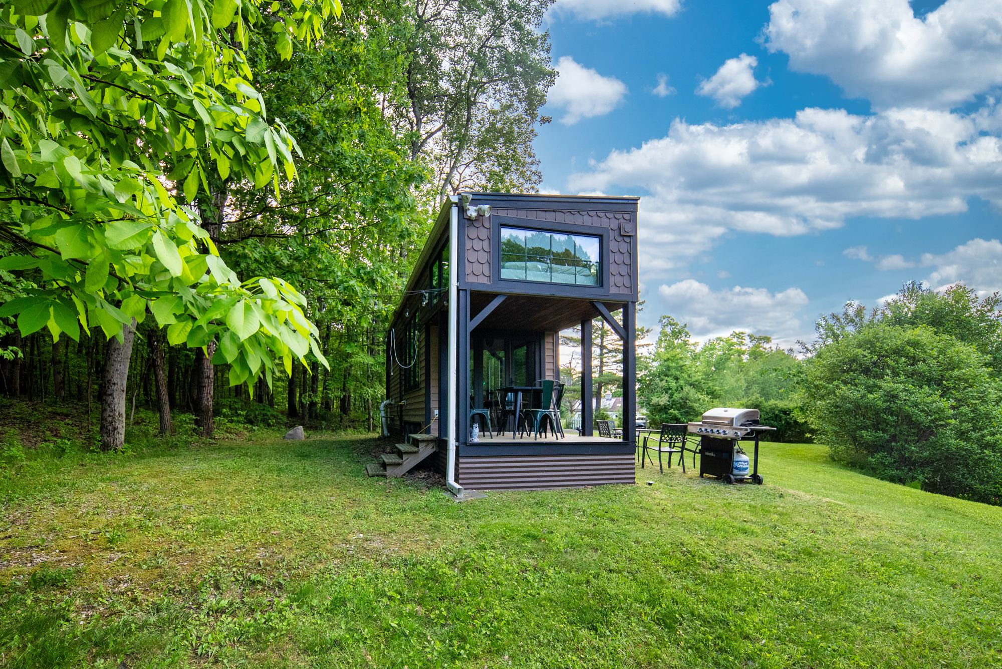 Tiny Home in the clearing under a blue sky