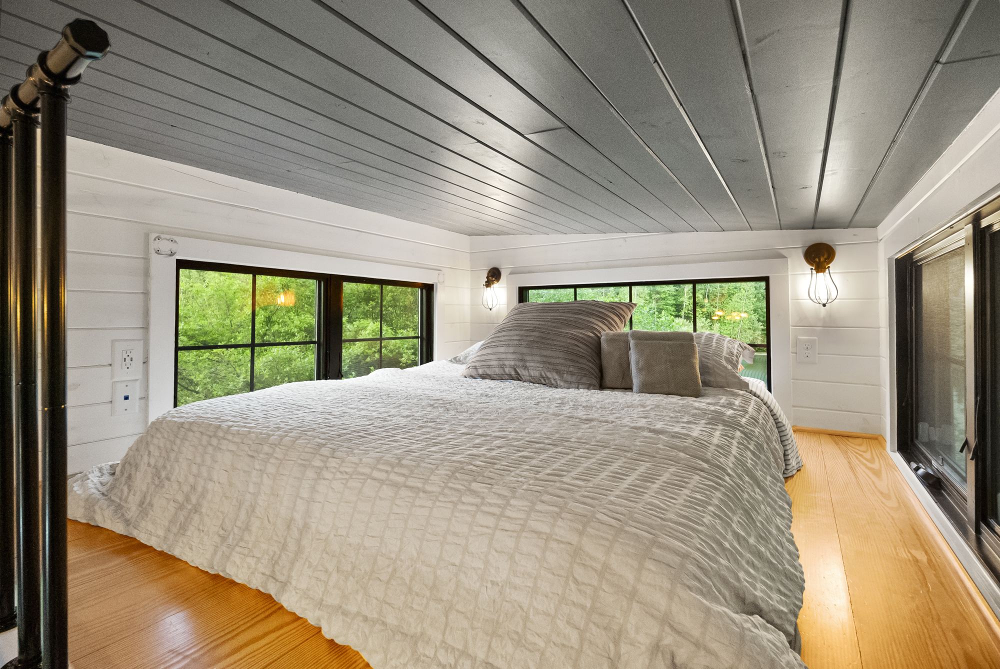 Sleeping loft with a window onto the trees